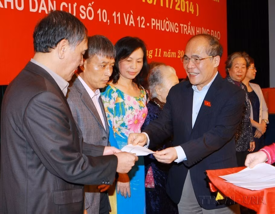 El presidente de la Asamblea Nacional, Nguyen Sinh Hung, entrega obsequios a familias culturales típicas en la Fiesta de Gran Unidad Nacional entre las zonas residenciales números 10, 11 y 12, distrito de Tran Hung Dao, Hanoi, en 2014. (Fuente: VNA)
