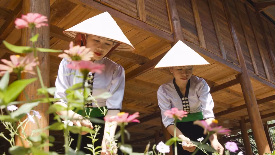 Mujeres de la minoría étnica Thai Blanca cuidan las flores para crear paisajes ambientales en la aldea turística comunitaria de Na Su. (Fuente:VNA)