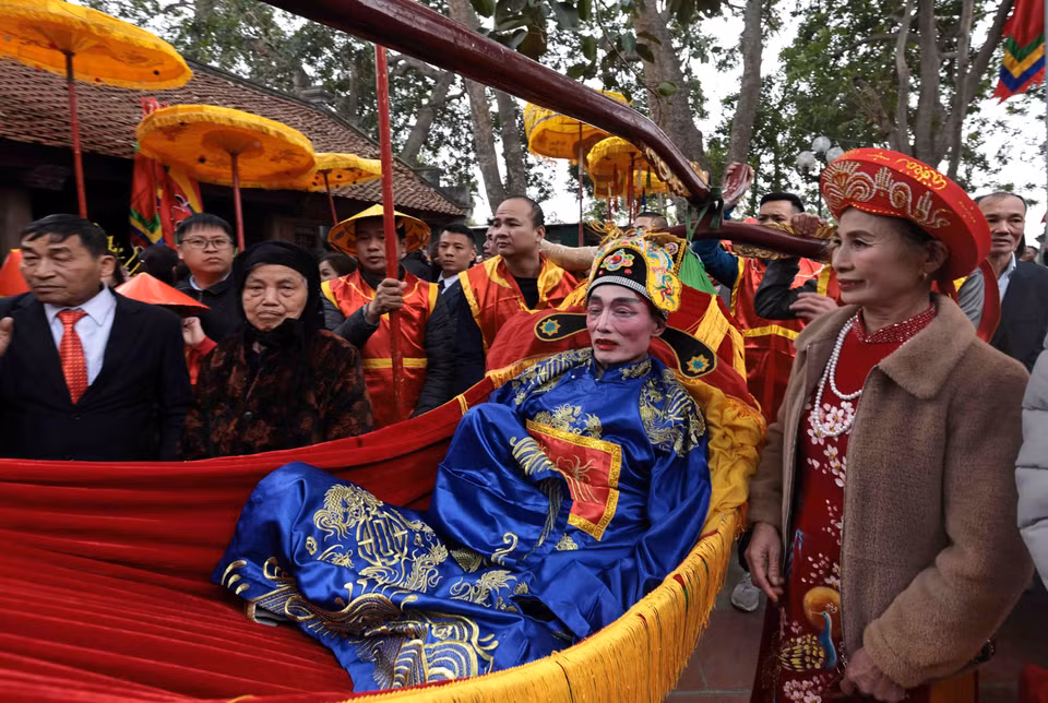 5. Además del Rey y el Señor, los aldeanos de Thuy Loi también llevan en procesión a cuatro altos funcionarios. En la foto: Procesión de un alcalde hacia el Templo Sai.