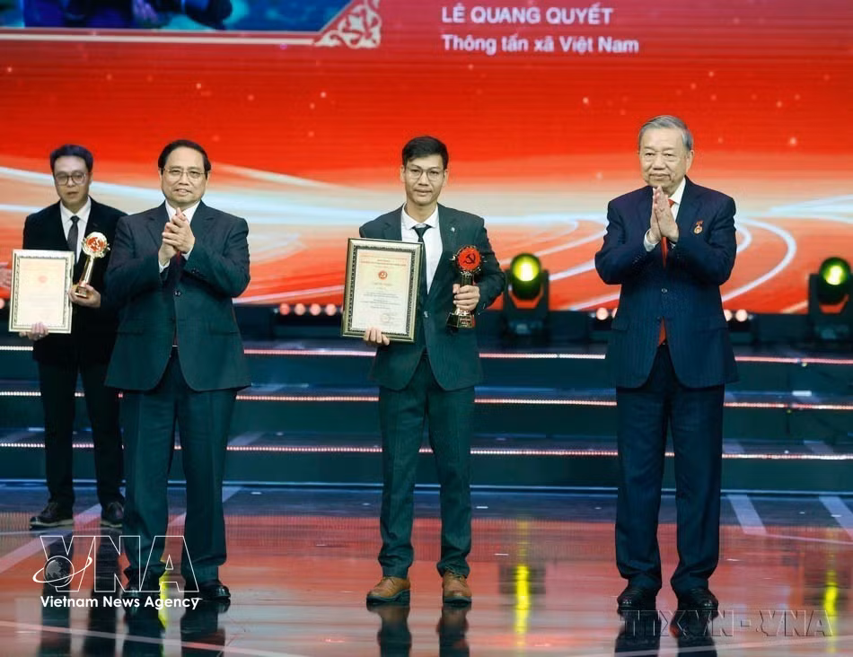 El secretario general del Partido, To Lam, y el primer ministro Pham Minh Chinh entregan el premio A al periodista Le Quang Quyet, de la VNA, durante la ceremonia de los X Premios Bua Liem Vang (Hanoi, 3 de febrero de 2026). (Foto: VNA)