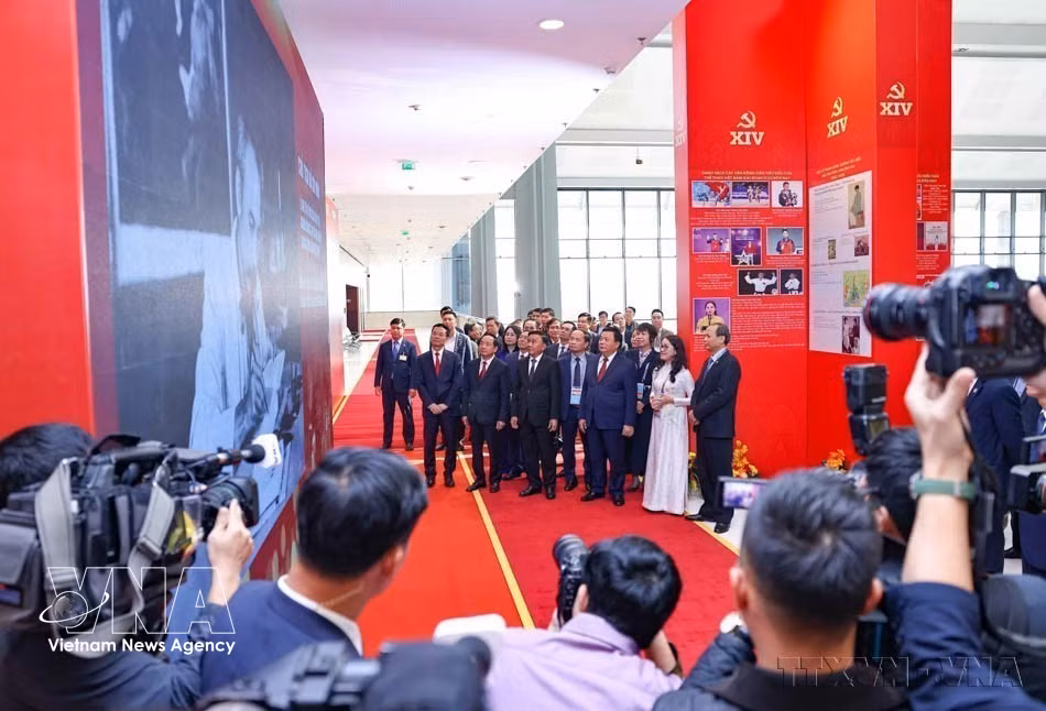 El miembro permanente del Secretariado del Comité Central del Partido, Tran Cam Tu, y otros dirigentes del Partido y el Estado visitan la exposición fotográfica “Bajo la bandera del Partido, el país entra en una nueva era”, organizada por la VNA durante la inauguración del Centro de Prensa del XIV Congreso Nacional del Partido (14 de enero de 2026). (Foto: VNA)
