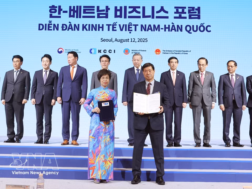 La directora general de la VNA, Vu Viet Trang, y el presidente de la agencia de noticias Yonhap, Hwang Dae-il, intercambian el acuerdo de cooperación profesional para la nueva etapa (Corea del Sur, 12 de agosto de 2025). Foto: VNA