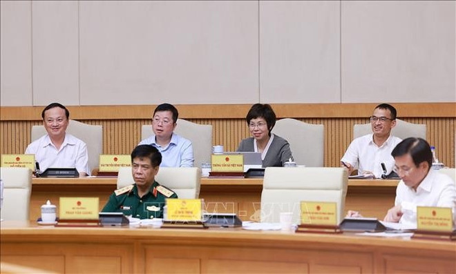 Delegados en la reunión. (Fuente: VNA) vna-potal-thu-tuong-chu-tri-hop-danh-gia-ket-qua-van-hanh-mo-hinh-chinh-quyen-dia-phuong-hai-cap-stand-1.jpg