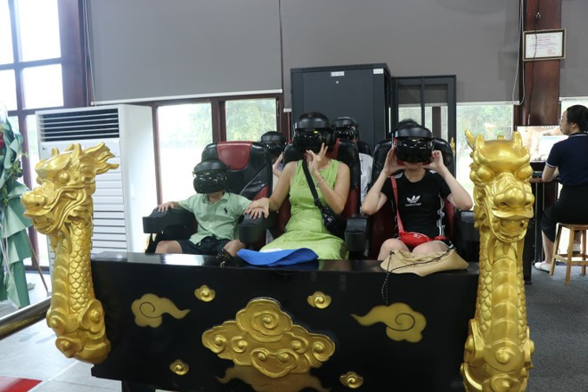 Turistas experimentan el servicio de realidad virtual "En busca del Palacio Real Perdido" en la Ciudad Imperial de Hue. (Foto: VNA) du-khach-trai-nghiem-dich-vu-thuc-te-ao-di-tim-hoang-cung-da-mat-trong-dai-noi-hue-anh-ttxvn.jpg