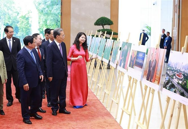 El primer ministro de Vietnam, Pham Minh Chinh, y el miembro del Comité Permanente del Buró Político y presidente del Comité Permanente de la Asamblea Popular Nacional de China, Zhao Leji, visitan una exposición fotográfica sobre la cooperación entre los dos países. (Fuente: VNA) vna-potal-thu-tuong-hoi-kien-uy-vien-truong-nhan-dai-toan-quoc-trung-quoc-8251677.jpg