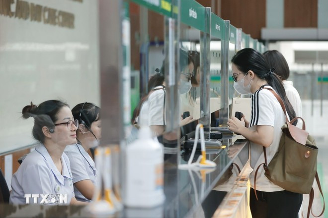 Las personas hacen cola para registrarse en el mostrador de recepción. (Foto: VNA) kham-benh.jpg