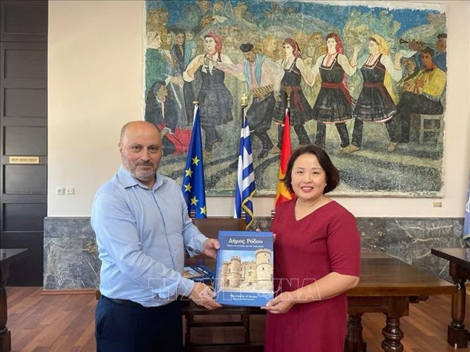 El vicealcalde de Rodas, responsable de economía, finanzas y patrimonio cultural, Chalkias Konstantinos, entregó un libro a la embajadora de Vietnam en Grecia, Pham Thi Thu Huong. (Fuente: VNA) hy-lap2-070825.jpg