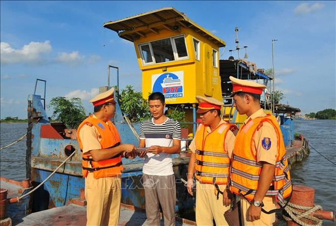 Oficiales difunden la ley a los propietarios de barcos. (Foto:VNA) canh-sat-250825-1.jpg