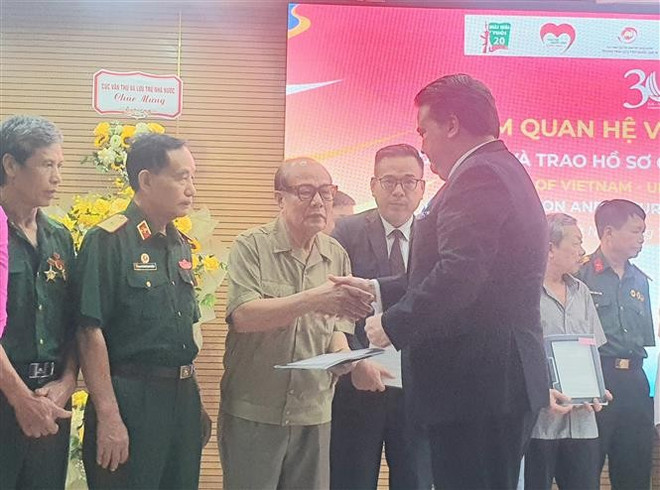 El embajador de Estados Unidos en Vietnam, Marc Knapper, entrega objetos de guerra a los veteranos. (Foto:VNA) vna-potal-trung-bay-30-nam-quan-he-ngoai-giao-viet-nam-hoa-ky-va-trao-tra-ho-so-chung-tich-chien-tranh-8141489.jpg