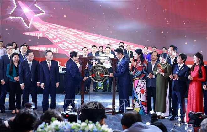 El primer ministro Pham Minh Chinh dirige la ceremonia de toque de gong para inaugurar una nueva fase de desarrollo en el Foro del Sector Privado de Vietnam. (Fuente: VNA) pmc.jpg