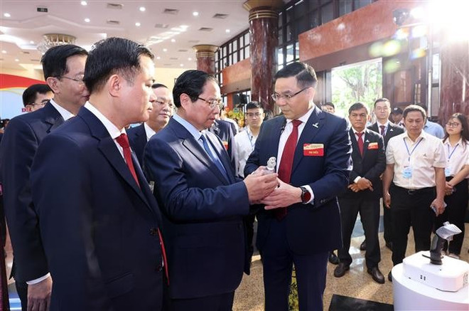El primer ministro Pham Minh Chinh asiste a la presentación de productos típicos de Petrovietnam. (Fuente: VNA) vna-potal-thu-tuong-du-dai-hoi-dang-bo-tap-doan-cong-nghiep-nang-luong-quoc-gia-viet-nam-8187430.jpg