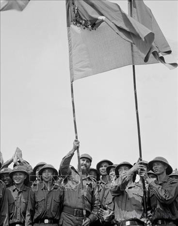 El primer secretario del Comité Central del Partido Comunista de Cuba y primer ministro del Gobierno Revolucionario, Fidel Castro, enarbola con orgullo la bandera tradicional de la Brigada Khe Sanh, del Ejército de Liberación de Tri Thien - Hue (Quang Tri, 15 de septiembre de 1973). Foto: VNA cuba.jpg