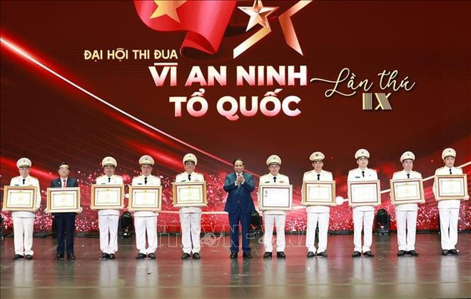 El primer ministro Pham Minh Chinh entrega el título de Héroe de las Fuerzas Armadas Populares y la Medalla de Mérito Militar de Primera Clase a colectivos e individuos con logros sobresalientes. (Foto: VNA) ttg-bca2.jpg