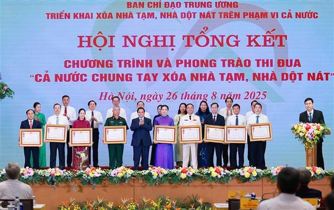 El primer ministro Pham Minh Chinh entrega la Orden del Trabajo de tercera clase a colectivos con logros destacados en el programa "Todo el país se une para eliminar viviendas precarias" (Foto: VNA) thumbstand.jpg