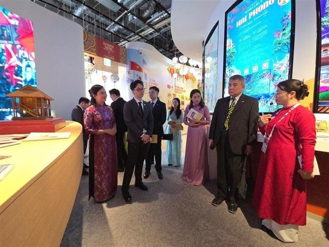 Los delegados visitaron y escucharon la presentación de la exposición "Presidente Ho Chi Minh - Símbolo de paz y amistad". (Foto: VNA) vna-potal-khai-mac-trien-lam-ve-chu-tich-ho-chi-minh-tai-expo-2025-8049517.jpg