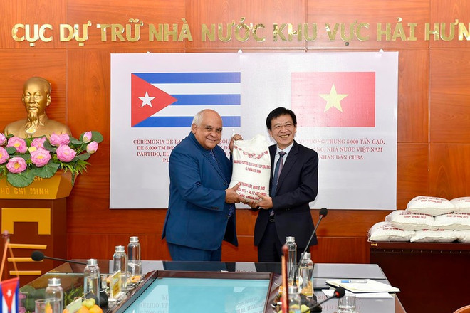 El subdirector general del Departamento General de Reservas Estatales, La Van Thinh, entrega simbólicamente cinco mil toneladas de arroz, un obsequio del Partido y Estado vietnamitas al pueblo cubano, a Orlando Nicolás Hernández Guillén, embajador de Cuba en Vietnam. (Foto: Vietnam+) a-trao-gao.jpg