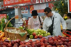 Extranjeros compran frutas en un mercado vietnamita. (Fuente: VNA)