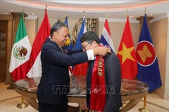 El embajador malasio en México Jamal Johan entrega la banda simbólica de la Presidencia de la ACMC al embajador de Vietnam en México, Nguyen Van Hai. (Fuente: VNA)