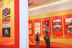 Turistas internacionales visitan una exposición por el aniversario 95 de la fundación del Partido Comunista de Vietnam. (Fuente: VNA)