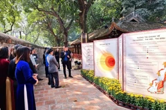 Los visitantes contemplan la exposición "Las estelas de piedra cuentan historias" (Fuente: Vietnam+) 