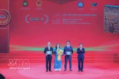 El miembro del Buró Político y jefe de la Comisión de Propaganda, Educación y Movilización de Masas del Comité Central del Partido Comunista de Vietnam, Trinh Van Quyet, entrega el premio A a los galardonados. (Fuente: VNA)