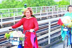 Stella Ciorra en un programa de ciclismo para promover el patrimonio del ao dai vietnamita (Fuente: nhandan.vn) 