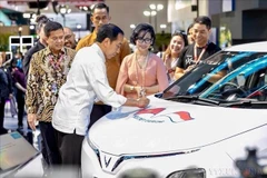 El presidente de Indonesia, Joko Widodo, firma en un carro de exhibición de VinFast durante la presentación del automóvil eléctrico con volante a la derecha de la empresa en Indonesia, el 15 de febrero de 2024. (Foto: VNA)