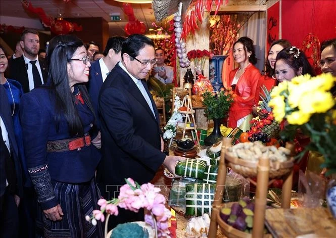 El primer ministro Pham Minh Chinh y su esposa visitan un puesto de productos del Tet en Polonia. (Foto: VNA)