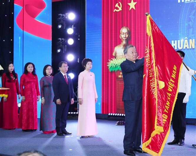 El secretario general del Partido Comunista de Vietnam, To Lam, coloca la Orden Ho Chi Minh en la bandera tradicional de la VNA. (Foto: VNA)