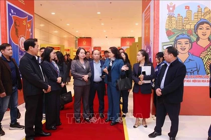 La subdirectora general de la Agencia de Noticias de Vietnam, Nguyen Thi Su, presenta la exposición fotográfica de la entidad en el XI Congreso Nacional de Emulación Patriótica a la vicepresidenta Vo Thi Anh Xuan. (Fuente: VNA)