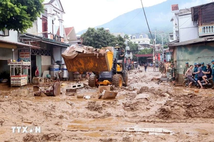 Se movilizaron excavadoras para nivelar y recoger el lodo, las ramas de árboles y la basura arrastrada por la reciente inundación en la comuna de Song Ma, provincia de Son La. (Foto: VNA)