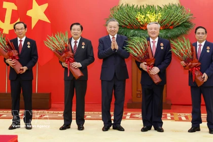 El secretario general del Partido Comunista de Vietnam (PCV), To Lam (centro) entrega Orden del Mérito Militar y de insignias de membresía del PCV a dirigentes y exlíderes del Partido y del Estado. (Fuente: VNA)