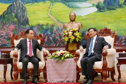 Thongloun Sisoulith, secretario general de PPRL y presidente de Laos, recibe Le Hoai Trung, ministro de Relaciones Exteriores de Vietnam. (Fuente: VNA)
