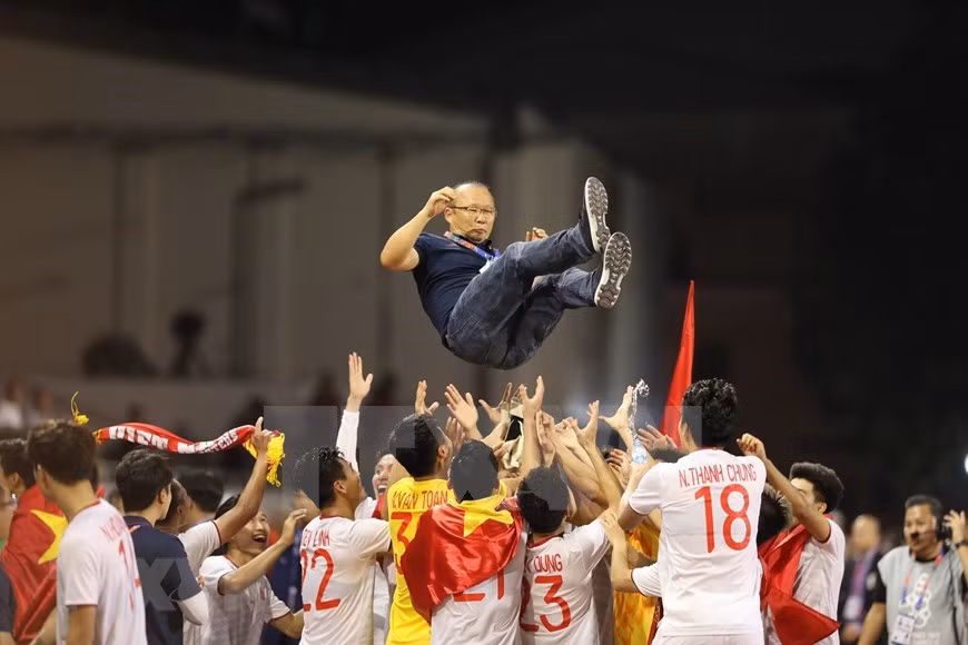 Jugadores vietnamitas levantan al entrenador Park Hang-seo en el aire para celebrar la primera medalla de oro de Vietnam en el fútbol masculino de SEA Games en Filipinas (Fuente: VNA)