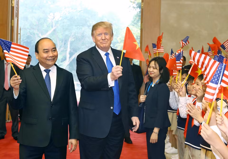 El primer ministro vietnamita, Nguyen Xuan Phuc, y los niños de Hanoi dan la bienvenida al presidente de Estados Unidos, Donald Trump, el 27 de febrero de 2019, en la sede del Gobierno. (Foto: VNA)