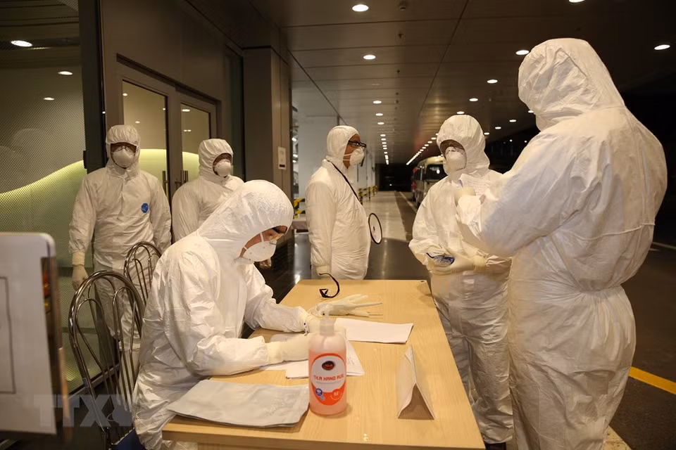 El personal del aeropuerto Van Don realizó los trámites de migración para los viajeros que regresaron de Wuhan (China). (Foto: VNA)