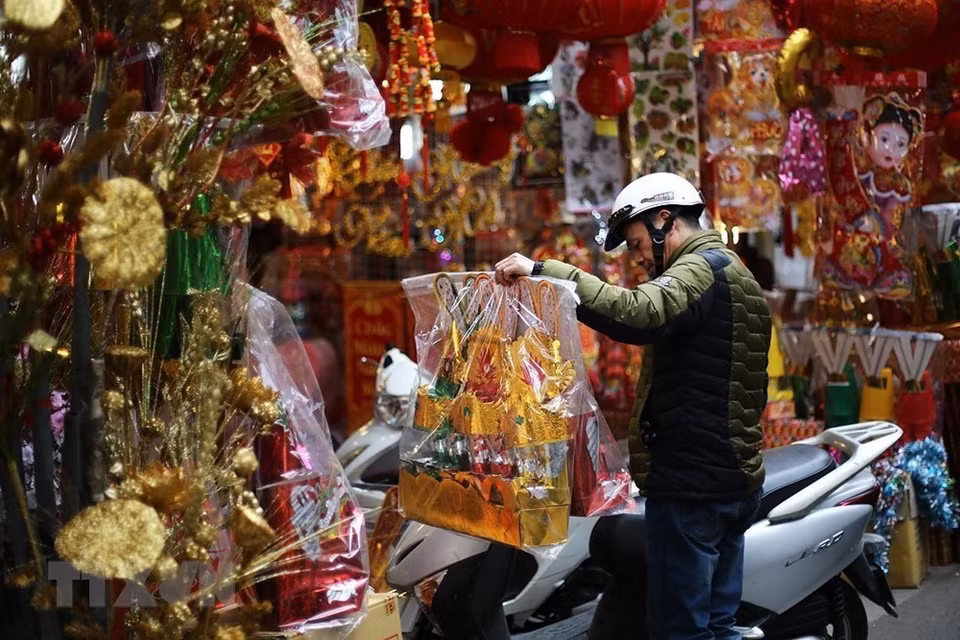 Por tan significativo acontecimiento, todos los hogares vietnamitas están ocupados preparando platos típicos y bebidas en ofrenda a esas deidades guardianas de la cocina. Se elaboran de manera cuidadosa las ofrendas, se queman ropas hechas de papel, de color rojo (símbolo de la buena suerte y la prosperidad), incluidos sombreros, mantos y calzados para rendir culto a esas divinidades (dos masculinas y una femenina), que son las que protegen a todas las familias en las cocinas de las casas. Foto: Hacen las compras preparatorias del rito dedicado a dioses de cocina (Fuente: VNA)