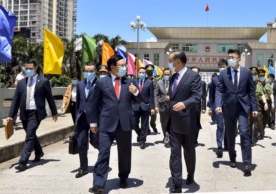 El viceprimer ministro y canciller Pham Binh Minh y el consejero de Estado y ministro de Relaciones Exteriores de China, Wang Yi, en la línea fronteriza del puente Bac Luan I, en el lado vietnamita. (Foto: VNA)