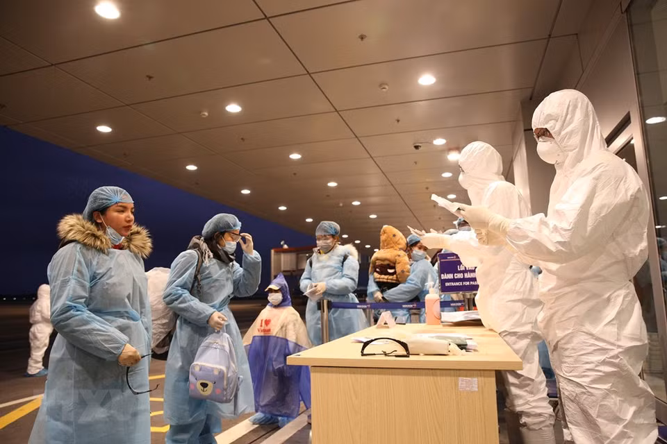 El personal del aeropuerto Van Don realizó los trámites de migración para los viajeros que regresaron de Wuhan (China). (Foto: VNA)