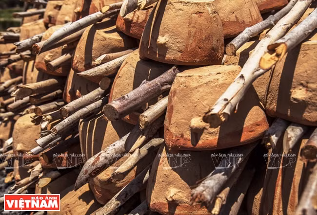  Se apilan las piezas cerámicas crudas con leñas en capas para honerarlas.