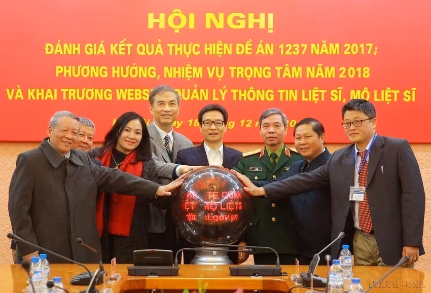 El viceprimer ministro vietnamita Vu Duc Dam, jefe del Comité Directivo Nacional 1237 sobre la búsqueda y recolección de los restos de los mártires, presionó el botón junto con otros delegados para inaugurar un sitio web acerca de la gestión de informaciones relativas a los héroes y mártires vietnamitas (Fuente: VNA)
