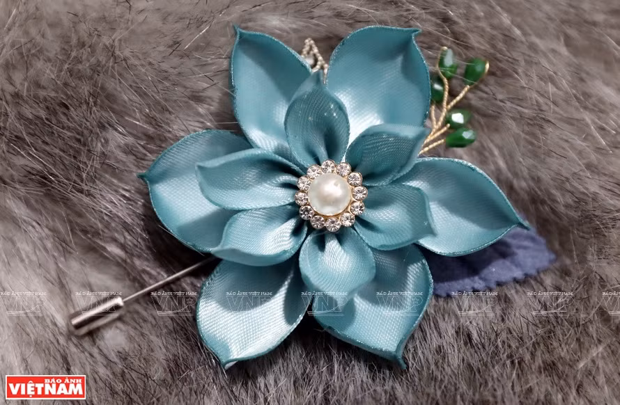 Los broches de flores son hechos con diferentes materiales, estilos y colores (Foto: VNA)