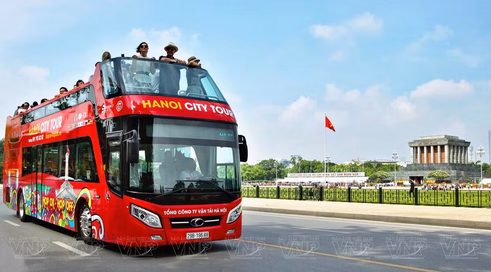 Turistas extranjeros en un autobús de dos pisos disfrutan del paisaje del Mausoleo dedicado al Presidente Ho Chi Minh y la plaza Ba Dinh (Fuente: VNA)