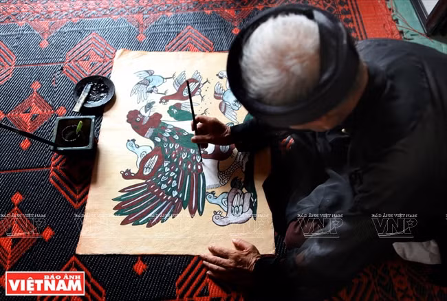 El artesano Nguyen Dang Che, de la aldea de Dong Ho, distrito de Thuan Thanh, provincia de Bac Ninh, da los toques finales a una pintura de gallo. Las pinturas populares de Dong Ho son muy buscadas por la gente en el norte durante el Tet (Fuente: VNA)