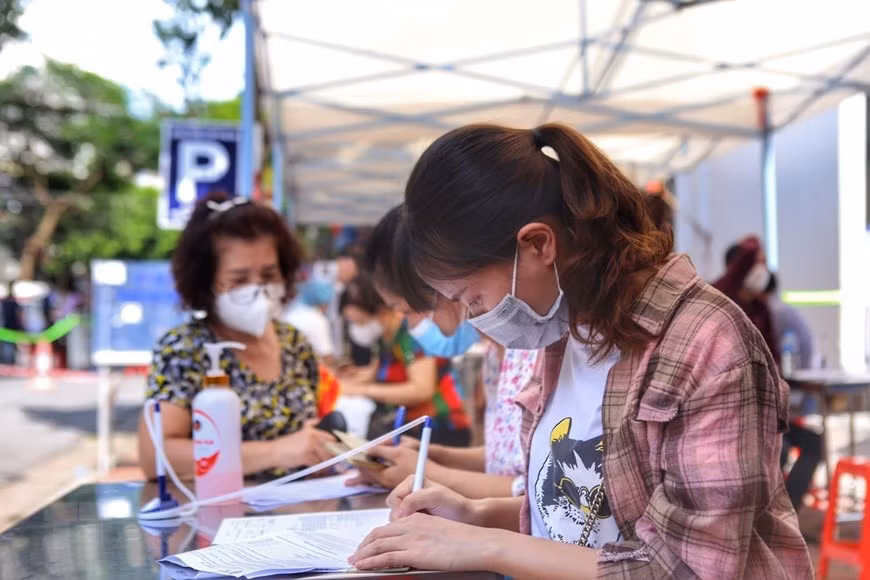 Pobladores del barrio Pham Dinh Ho, del distrito de Hai Ba Trung, realizan declaración médica antes de vacunarse (Fuente: VNA)