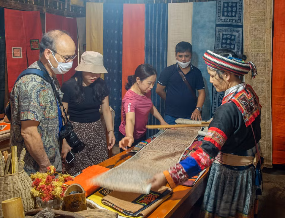 Los turistas visitan y compran productos tejidos con lino. (Foto: VNA)