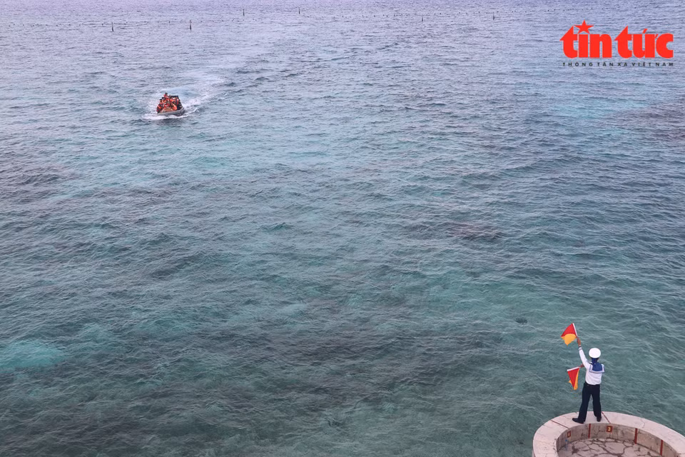 El soldado guía el barco a la isla de Da Tay B. (Foto: Periódico Tin Tuc)