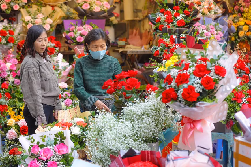 En la calle de Hang Ma, muchas tiendas han comenzado a vender regalos para que las parejas enamoradas puedan comprar y darse un regalo significativo en la noche del 14 de febrero. Las tiendas de flores en la calle de Tran Xuan Soan también están llenas de gente para comprar obsequios para sus enamorados. En un ambiente especial, muchas personas no pueden evitar sentirse encantados y sorprendidos cuando la calle de repente se vuelve hermosa y brillante con la aparición de carros de flores móviles. Aunque todavía no es de noche, las parejas se cogen de la mano cariñosamente, disfrutando del ambiente del Día de San Valentín. (Foto: PV/Vietnam+) 