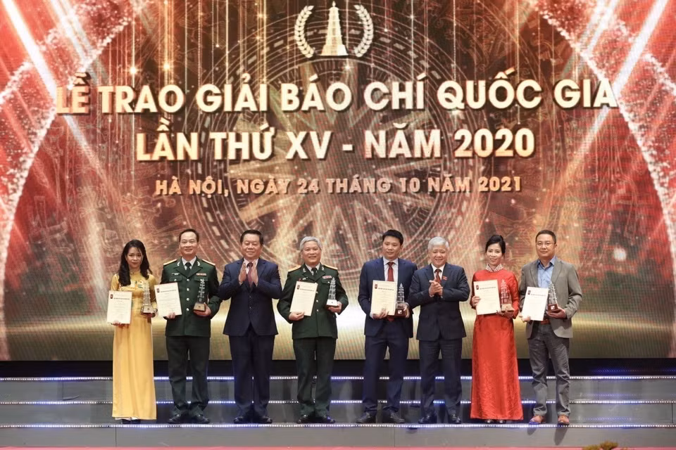 El jefe del Departamento de Propaganda y Educación del Comité Central del Partido Comunista de Vietnam, Nguyen Trong Nghia, y el presidente del Comité Central del Frente de la Patria de Vietnam, Do Van Chien, entregan premios a los autores y grupos de periodistas ganadores en el 15º Premio Nacional de Prensa 2020. (Foto: VNA)