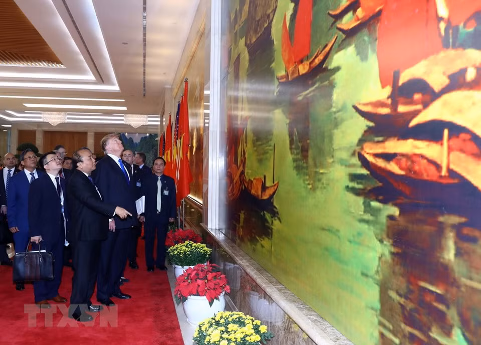 El primer ministro Nguyen Xuan Phuc presenta al presidente norteamericano, Donald Trump, cuadros de Vietnam. (Foto: VNA)